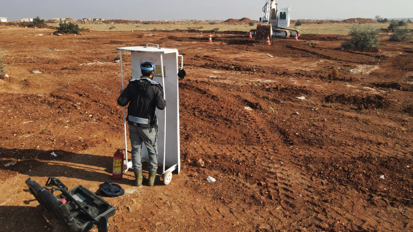 أعضاء منظمة هالو تراست يعملون على إزالة الألغام من حقل بمحافظة إدلب السورية في 19 ديسمبر 2024 (AFP)