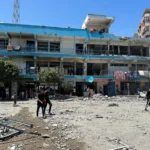 فلسطينيون يتفقدون موقع غارة إسرائيلية على مدرسة تابعة للأونروا تأوي نازحين في مخيم النصيرات للاجئين، 6 يونيو/حزيران 2024 (رويترز)