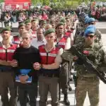 عناصر من قوات الأمن التركية يقودون الجنرال التركي السابق أقين أوزتور المنفذ الأساسي لمحاولة الانقلاب إلى قاعة المحكمة