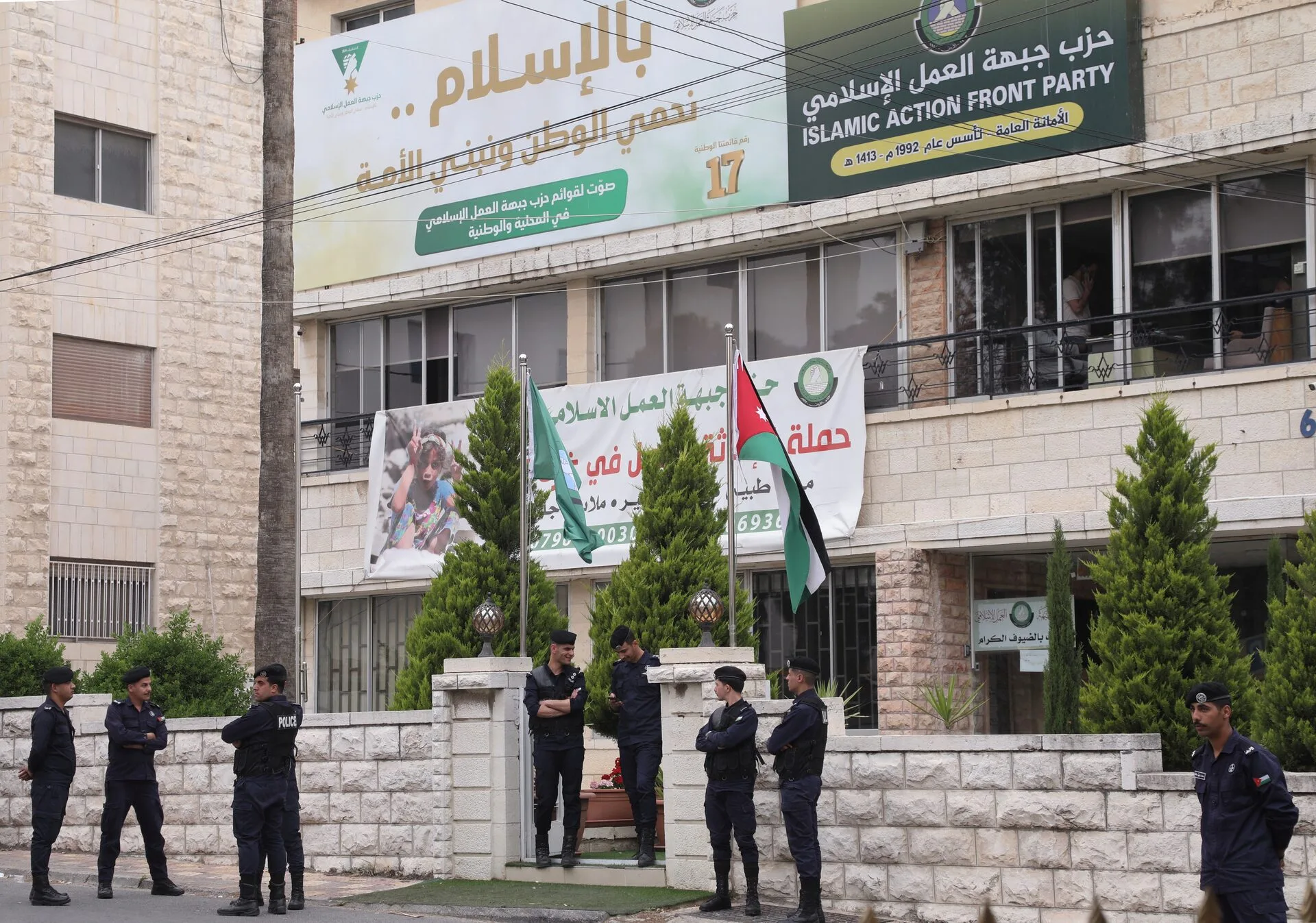 من "الجبهة" إلى "الأمة".. كيف يعيد إسلاميو الأردن بناء بيتهم السياسي؟ 26 أفراد من الشرطة الأردنية يقفون خارج مقر حزب جبهة العمل الإسلامي في عمان يوم 23 أبريل/ نيسان 2025 (رويترز)