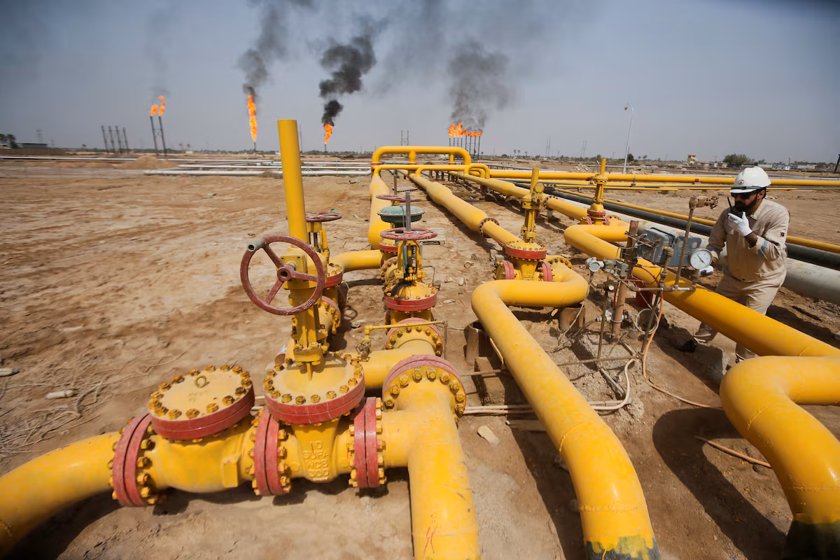 عامل يتفقد خط أنابيب نفط في حقل نهر بن عمر النفطي شمال البصرة بالعراق يوم 22 مارس/آذار 2022 (رويترز)